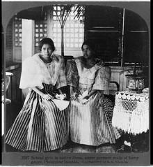 Dos escolares posan con vestimentas tradicionales hechas con textiles de cáñamo. Fotografía por N. Bennington en 1907